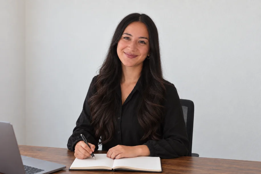 Esra Medik sitting at her desk with a pen and notebook